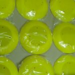 Yellow donuts wrapped in plastic, arranged in a grid pattern.