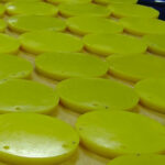Yellow plastic discs arranged on a wooden surface.