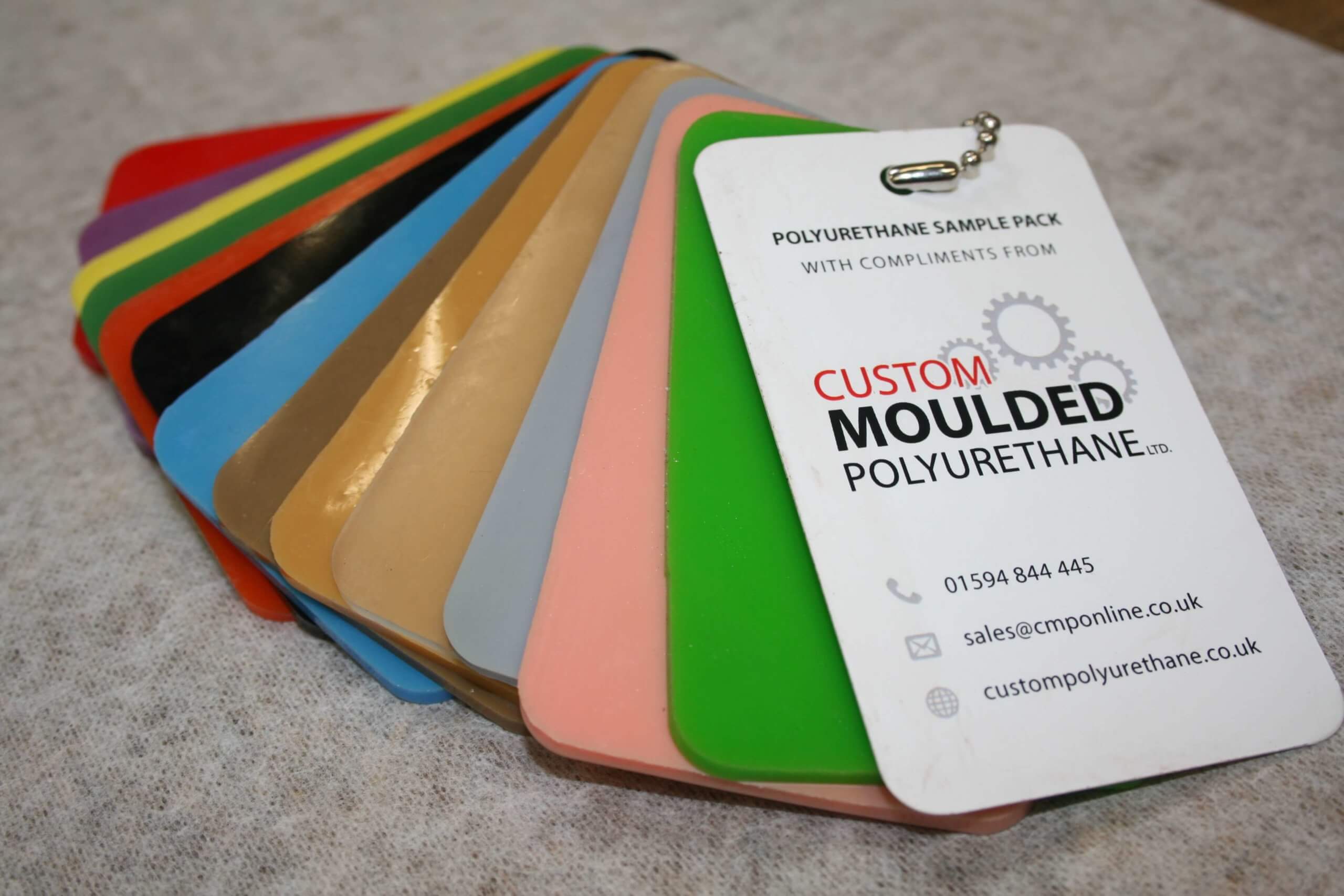 Sample cards fanned out with text: "Custom Moulded Polyurethane."