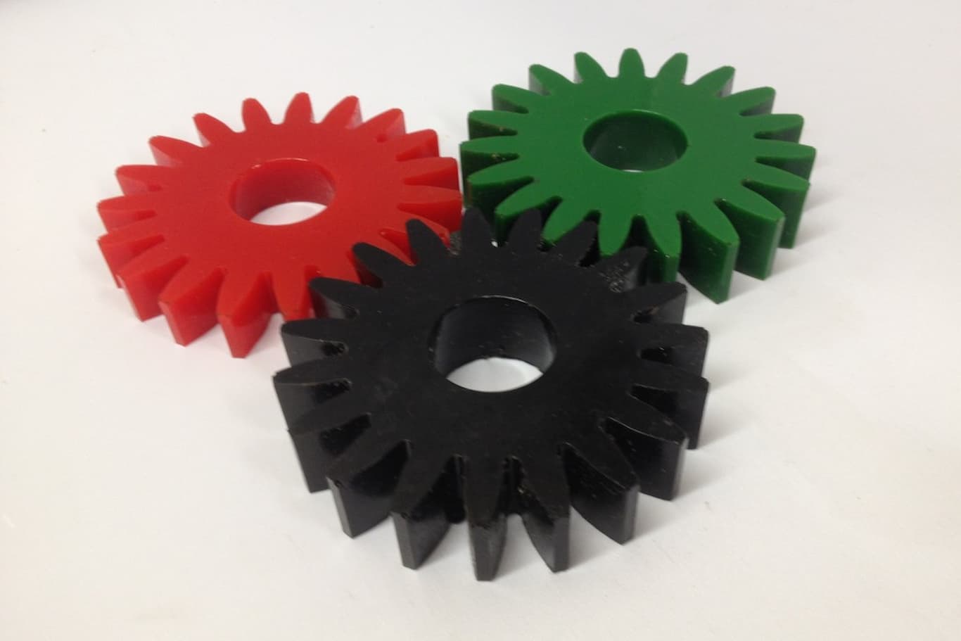 Colored gears lying together on a white surface.