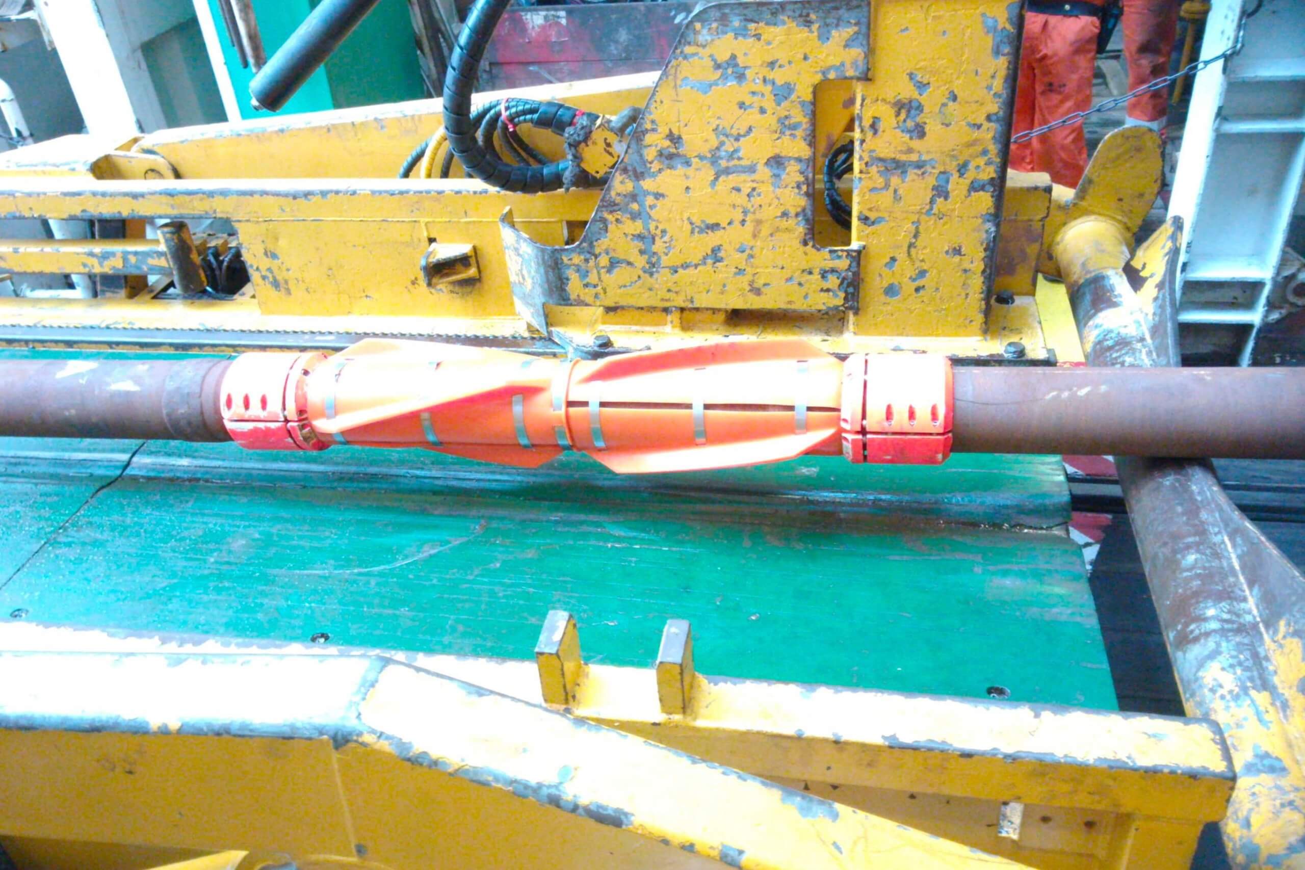 Pipe stabilizer resting on machinery in an industrial setting.