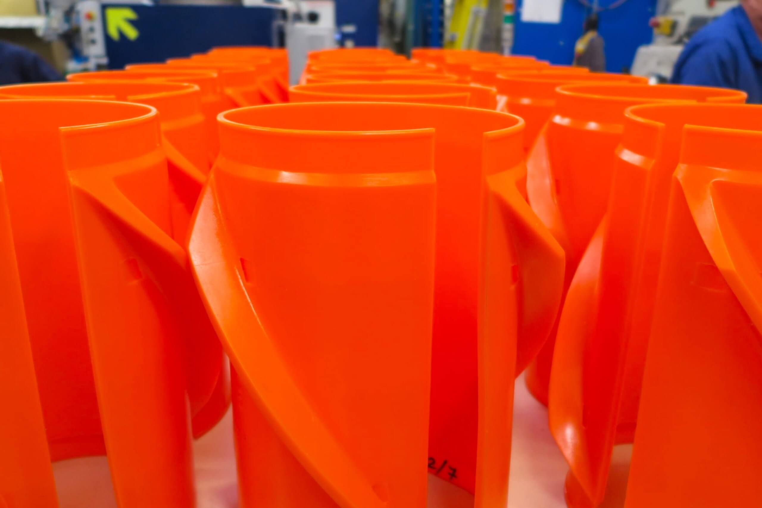 Orange plastic jugs arranged closely on a table, workshop background.