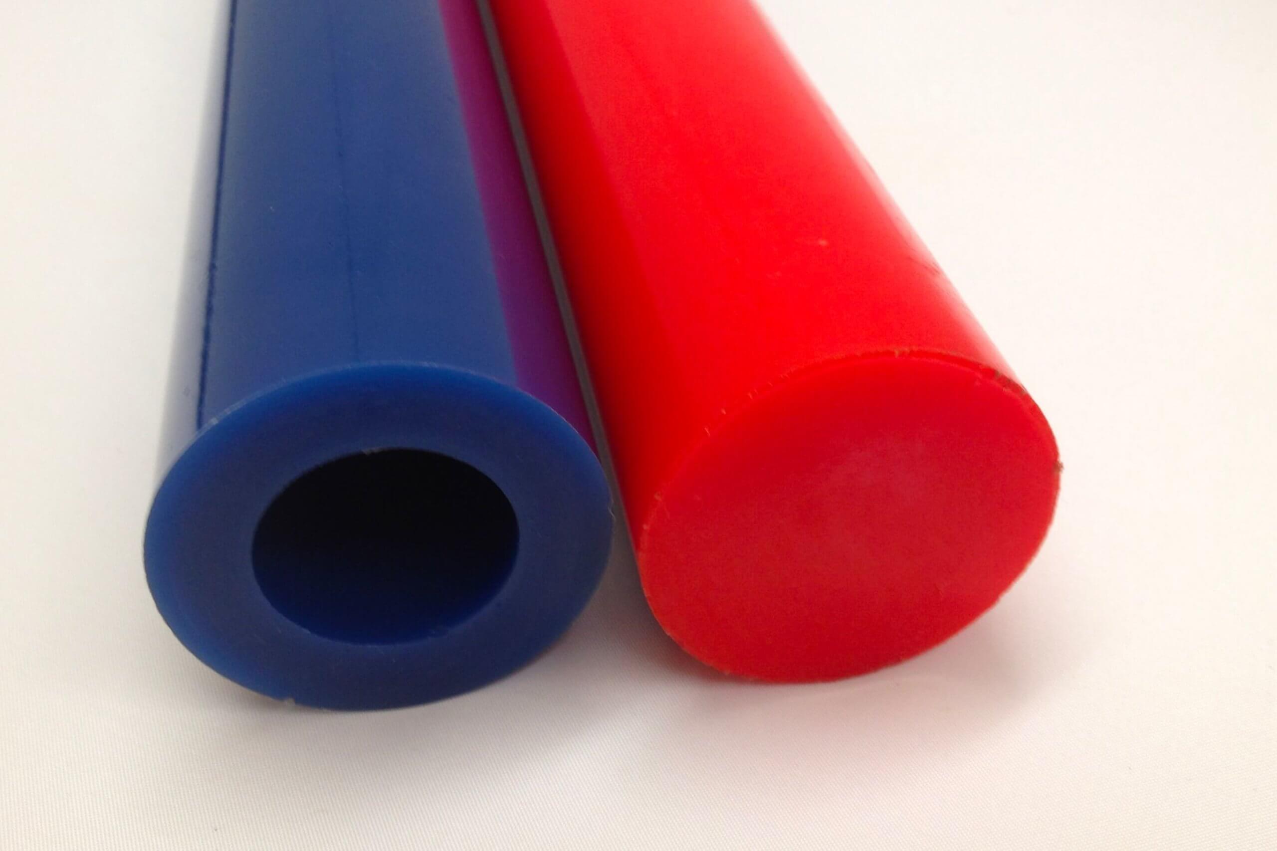 Blue hollow cylinder beside solid red cylinder, on white background.