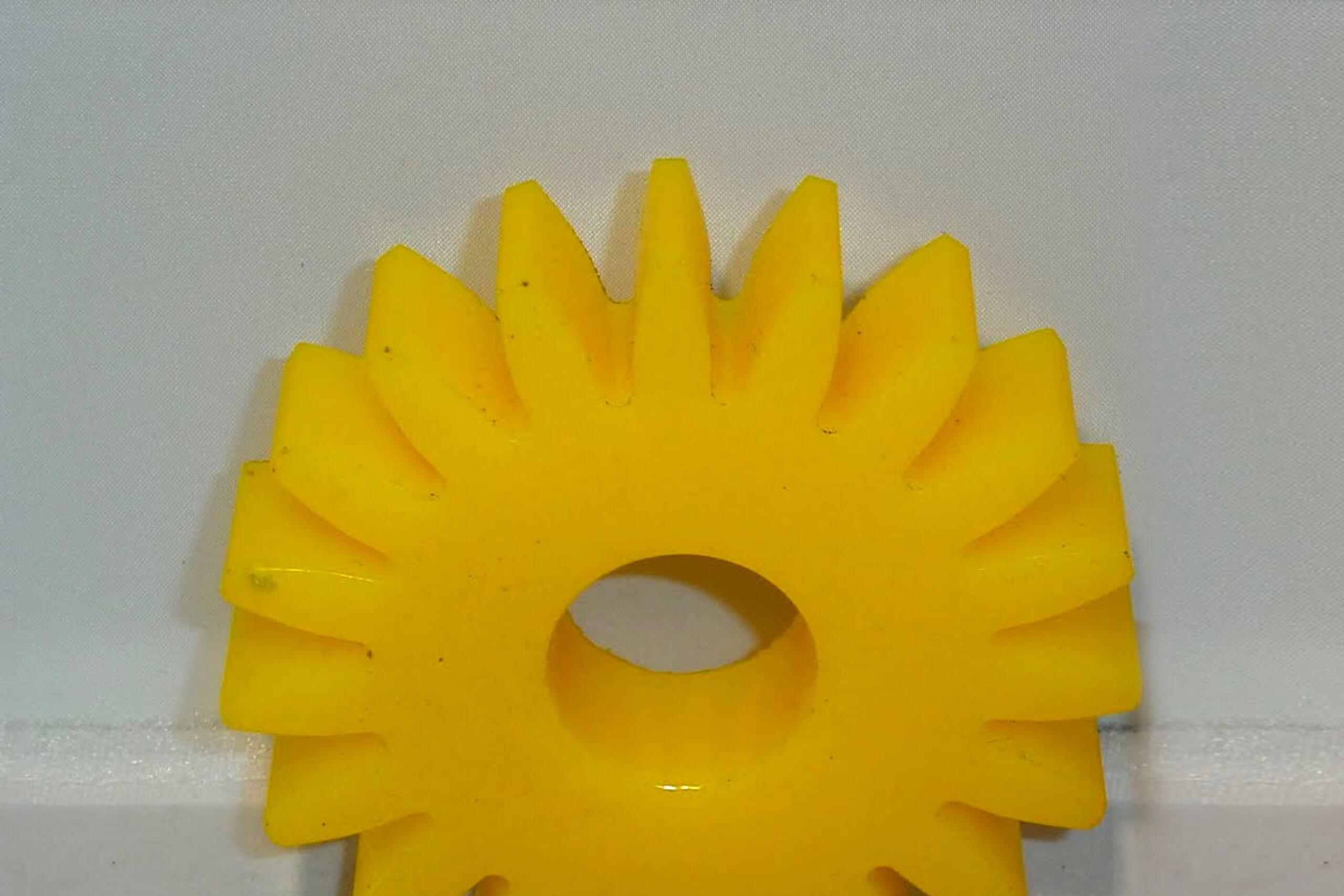 Yellow gear resting against plain background.