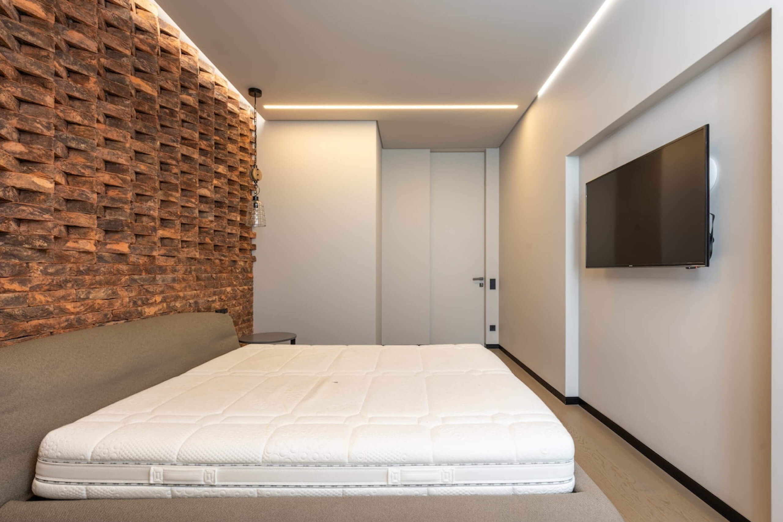 Bed in modern room with wood accent wall.
