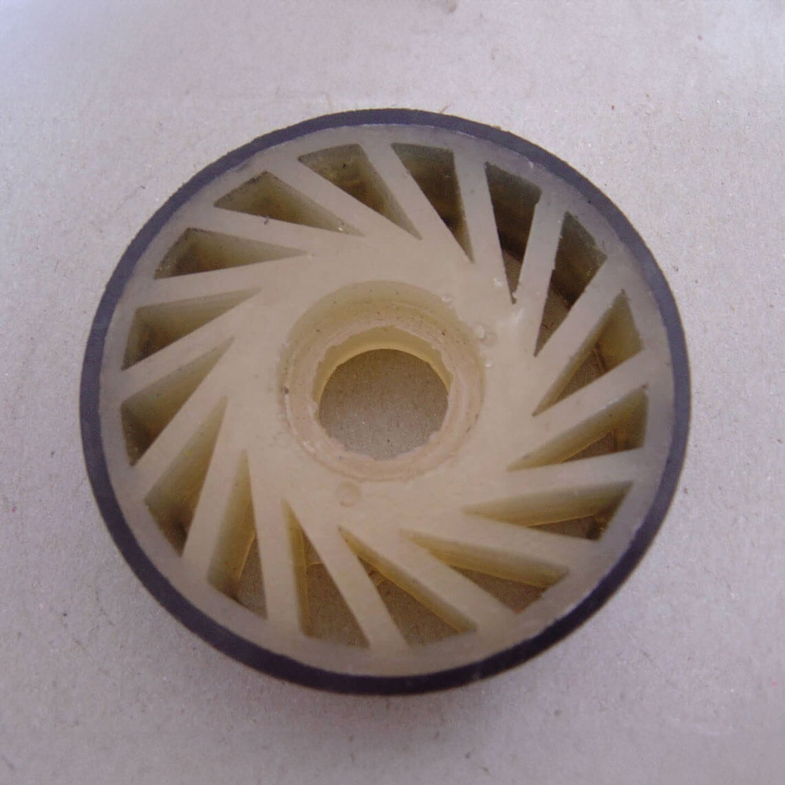Circular gear with triangular spokes on a flat surface.