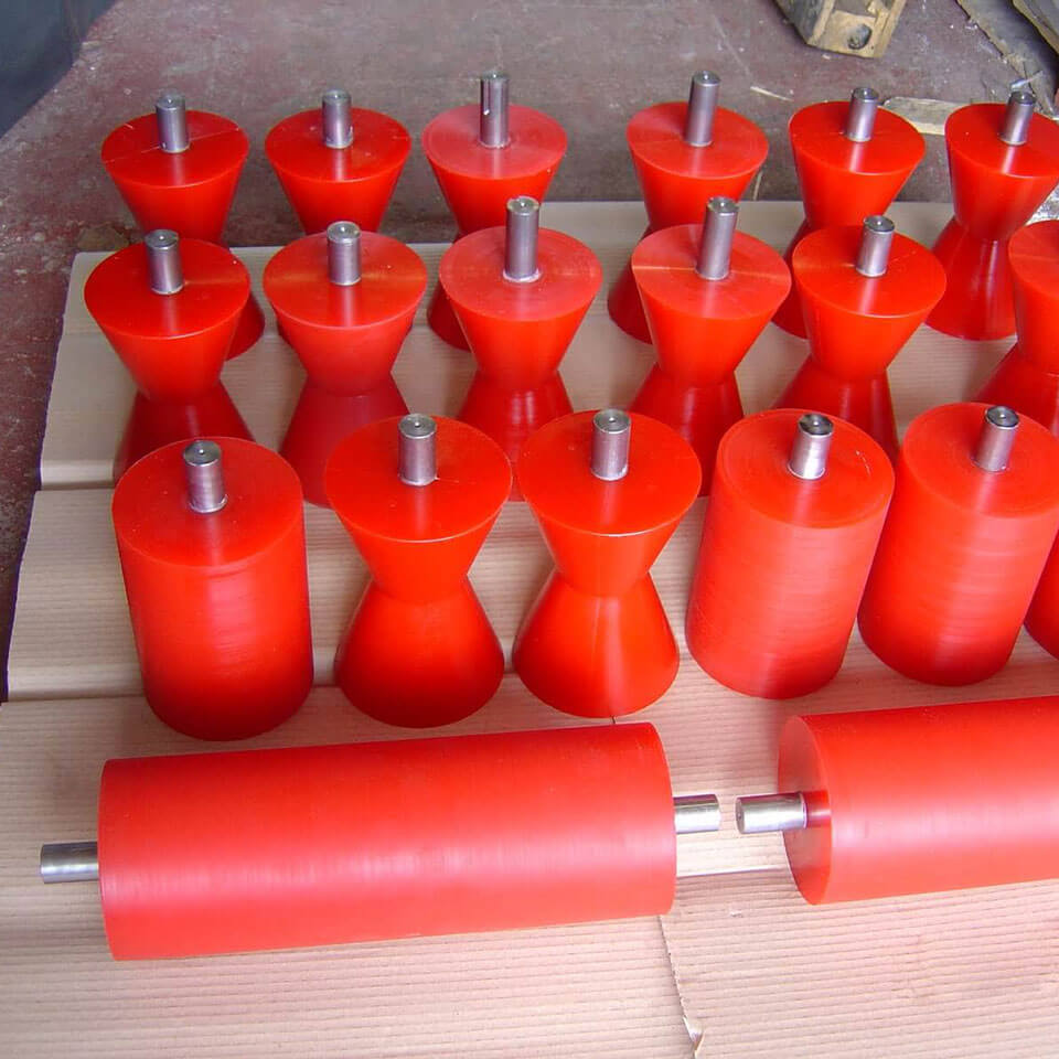 Red rubber rollers arranged on cardboard in a warehouse.