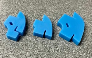 Three blue puzzle pieces arranged on a speckled surface.