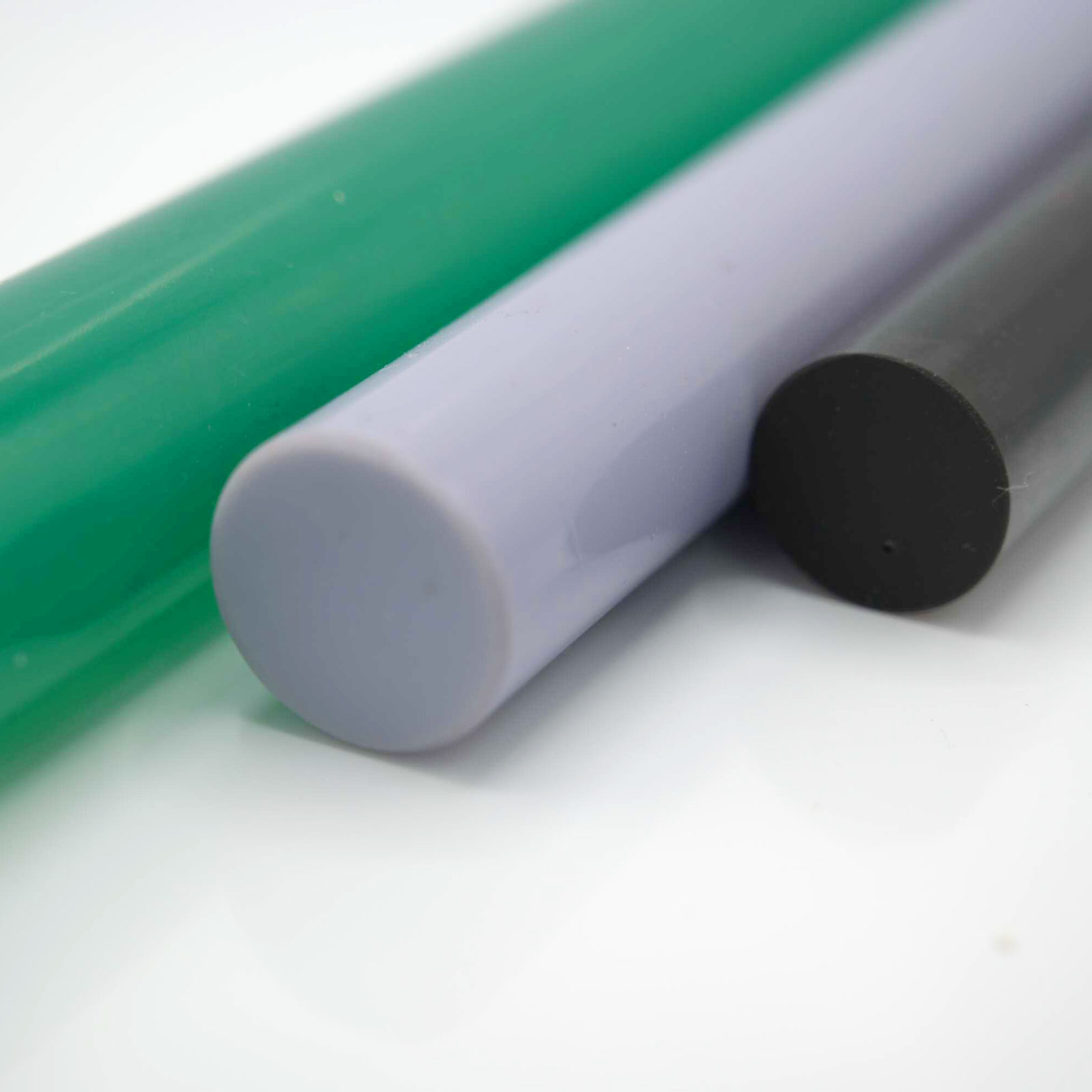 Colored plastic rods resting on reflective white surface.