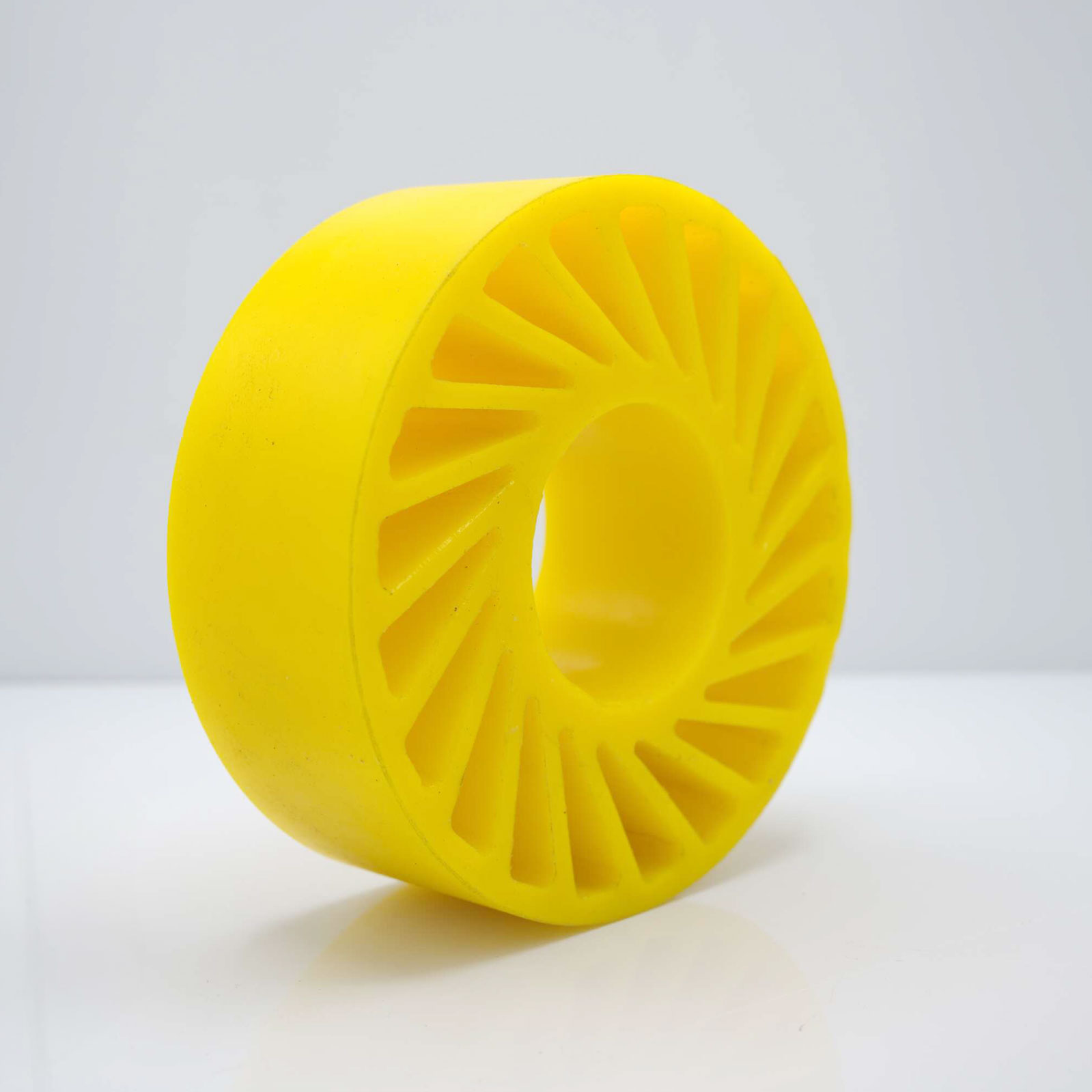 Yellow wheel standing upright, white surface, plain background.